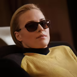 a woman with sunglasses sitting on a couch