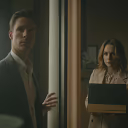 a woman holding a folder next to a man in a suit