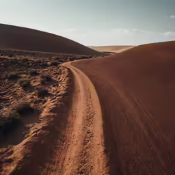 there is a dirt road that is going through a desert