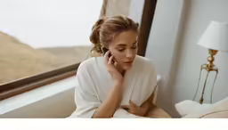 a woman talking on her cell phone next to a window