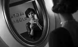 an older fashion woman reflected in a round mirror