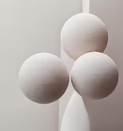 three balls are sitting next to each other in front of a white wall