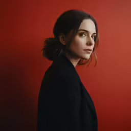 the woman is posing for a portrait on a red background