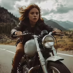 a woman riding a motorcycle down a street