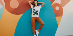 a woman leaning against a blue and colorful wall