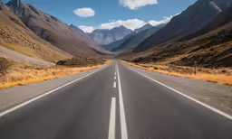 a long road with mountains in the background