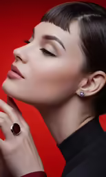 a woman holding up her hand next to a pair of earrings
