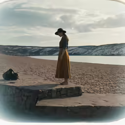 a woman is walking along a rocky beach