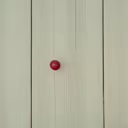 a small apple sitting on a white surface