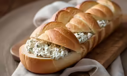 bread filled with spread, sitting on a cutting board