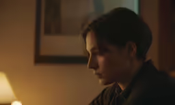 a woman is sitting with her head tilted looking towards the ground