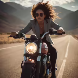 a woman on a motorcycle driving down an empty road