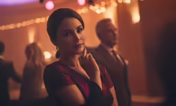 a woman in red is staring intently at the camera