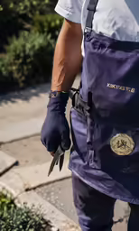 a man is holding scissors while standing on the sidewalk
