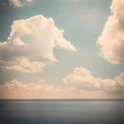 a blue sky with puffy white clouds and a boat out on the water