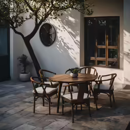 a patio with a tree and a clock on the wall