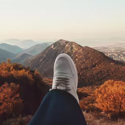a person sitting on top of a mountain looking down