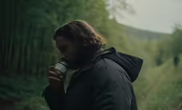 a man is standing with a camera in his hand