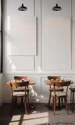 an empty restaurant with two small round tables and some chairs