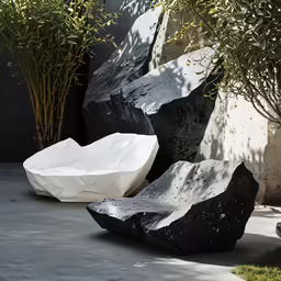 black and white rock sculptures by trees on sidewalk