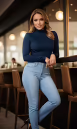 a beautiful woman in blue jeans posing for the camera