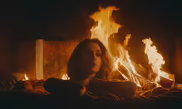 woman sitting on the couch by the fire
