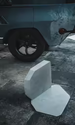 a cement object sitting in the street near a van
