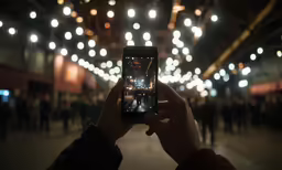someone holding up a smart phone in the dark
