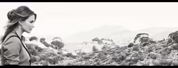 black and white image of woman looking out on mountains