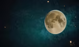 a full moon shining above the sky at night