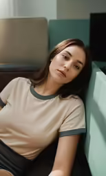 a woman sits on a couch in an empty room