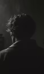 a man sits on a chair watching something on the wall