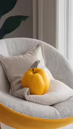 an orange is on top of the pillow in the chair