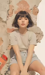a woman in short shorts sitting down against a wall