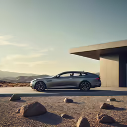 a silver sport wagon in front of a desert landscape