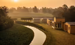 a beautiful country side with green fields, houses and animals grazing