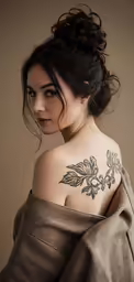 a woman has a tattoo on her upper shoulder
