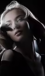 a young blond woman poses for the camera in her image