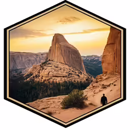 a man walking along the side of a cliff during sunset