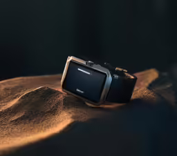 a watch sitting on top of a sandy surface