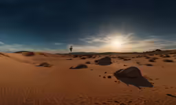 a desert scene with sun low in the sky