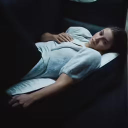 a woman laying on a couch in a dark room