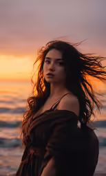 the woman is standing on the beach near the water