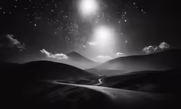an empty road passing through mountains with two stars