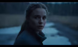 a woman with long blonde hair looking off into the distance