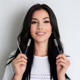 the woman is holding some hair straighteners