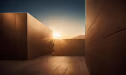 the sun setting on the horizon behind two concrete buildings