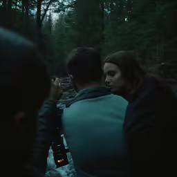 a man and a woman in the woods with lights