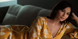 woman sitting on couch in dress and looking at camera