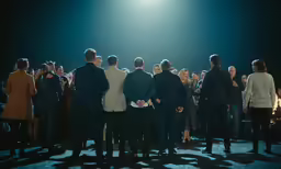 group of people standing next to each other in front of a light